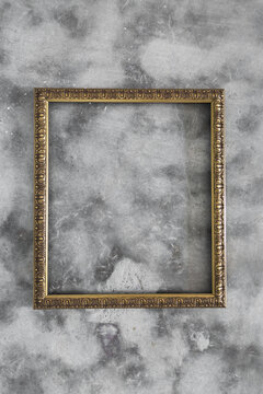 Empty gold frame on concrete background with copyspace