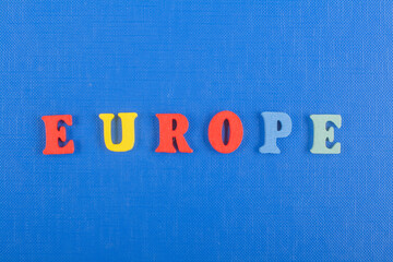 EUROPE word on blue background composed from colorful abc alphabet block wooden letters, copy space for ad text. Learning english concept.