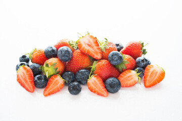 Fresh summer berries, strawberries and blueberries in water drops, isolated on a white background, top view, background