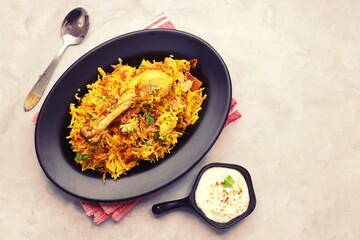 Chicken Biryani/murg Pulao.  Garnished with fried onion & chopped coriander. Biryani raita is a famous Spicy non vegetarian dish of India. Chicken cooked along with Basmati rice & spices. copy space.