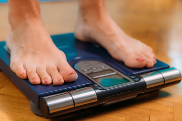 Woman Measuring Body Fat with Body Composition Monitor