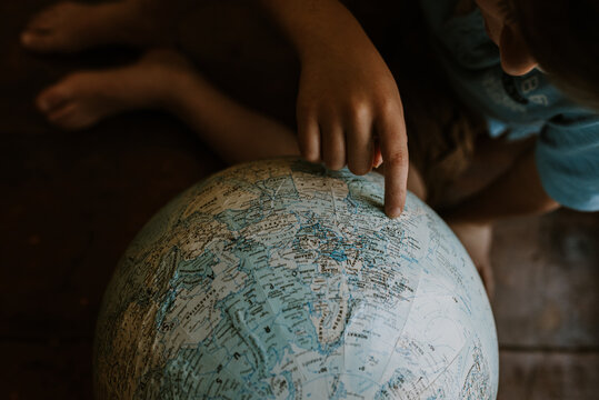 little boy looking at globe