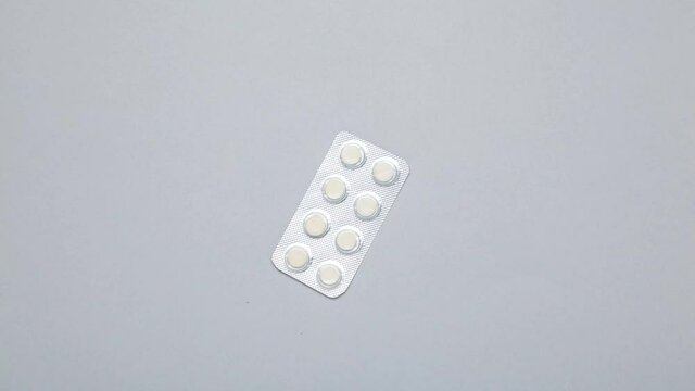 Stop Motion medical pills on grey background.