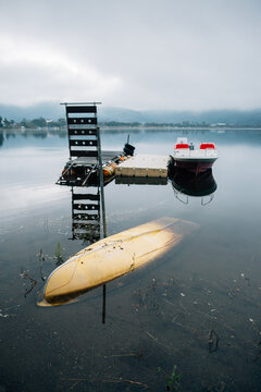 Overturned Yellow Canoe in Lake on Foggy Morning