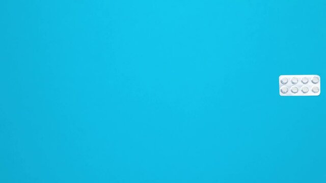 Stop Motion medical pills moves on blue background.