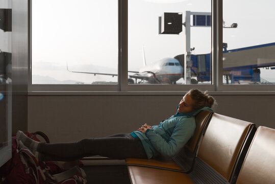 Young woman relaxing in the airport departure lounge before boar