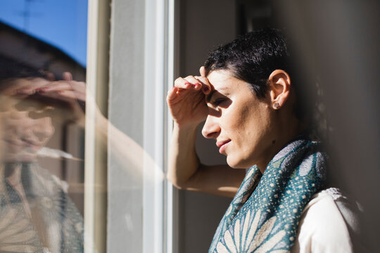 Brunette woman looks out the window