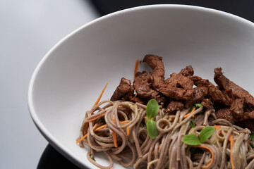 Thai soba salad in white bowl. Stir fry noodles, Soba salad with vegetables and meat.