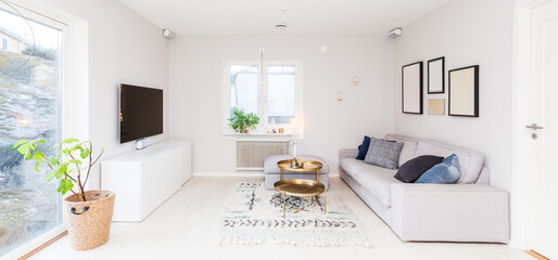 Header of a stylish livingroom with white furniture an a TV