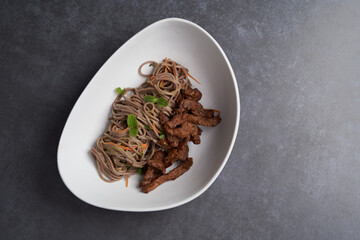 Thai soba salad in white bowl. Stir fry noodles, Soba salad with vegetables and meat.