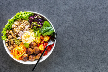 Grilled chicken, rice, spicy chickpeas, avocado, cabbage, pepper buddha bowl on dark background, top view. Delicious balanced food concept