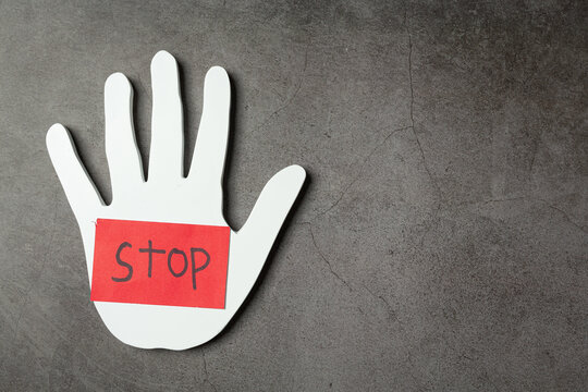 word "stop" in white hand on dark background