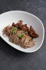 Thai soba salad in white bowl. Stir fry noodles, Soba salad with vegetables and meat.