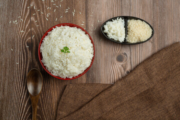 White rice is placed in a cup on the wooden floor.