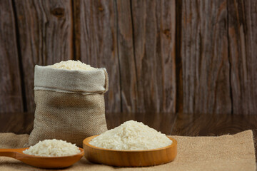 White rice is placed in a cup on the wooden floor.