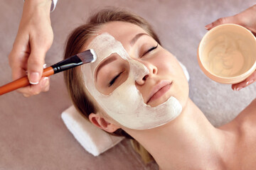 Face peeling mask, spa beauty treatment, skincare. Woman getting facial care by beautician at spa salon, close-up