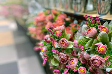 selective focus at beautiful artificial bouquet flowers in front of blurred florist shop.
