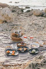 Fototapeta na wymiar Romantic brunch picnic with champagne and fresh homemade food near sea