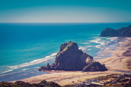 Retro-style photo of Lion Rock in the centre of Piha beach. on a beautiful summer day. Auckland, New Zealand.