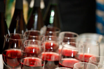 Viele Flaschen und Gläser mit Rotwein auf Bankett, Catering oder Event.