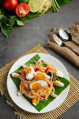 Papaya salad served with rice noodles and vegetable salad Decorated with Thai food ingredients.