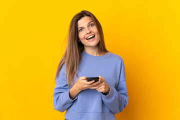 Young Slovak woman isolated on yellow background surprised and sending a message