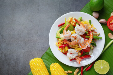 Som Tum with Corn and Shrimp, served with rice noodles and green salad Decorated with Thai food ingredients.