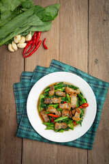 Stir fried kale, spicy crispy pork on wooden table Thai food concept.