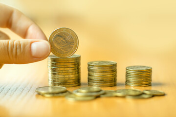 Stacks of coins, hand putting money coin stack growing