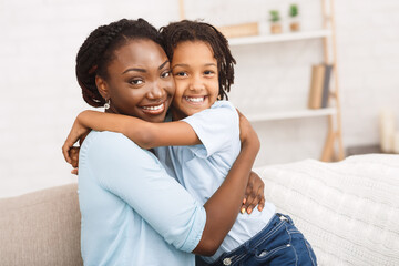 Obraz premium Black mother and daughter hugging at home