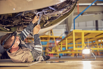 Aviation mechanic is checking big jet before departure