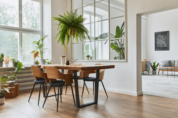 Stylish and botany interior of dining room with design craft wooden table, chairs, furniture, a lof...