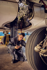 Fototapeta na wymiar Aircraft worker checking airplane under the aircraft