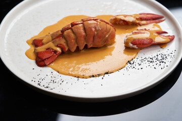 Seafood lobster with soup sauce. Cooked lobster on restaurant table, close-up