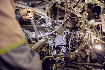 Aviation mechanic is working on undercarriage area