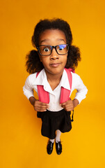 Shocked African School Girl Looking At Camera Standing Over Yellow Background