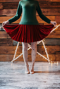 Crop woman in skirt on tiptoes