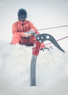young male freeskier in action during crevasses rescue with an icepick