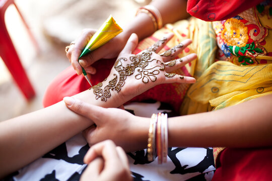 Teenage girl decorated hand with Mehendi