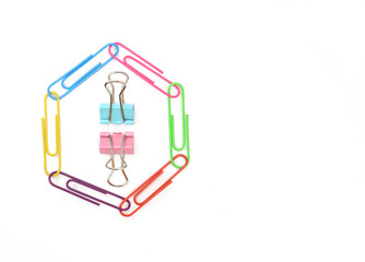 Colored paper clips lined with a polygon and two clothespins for paper in the center of the figure.