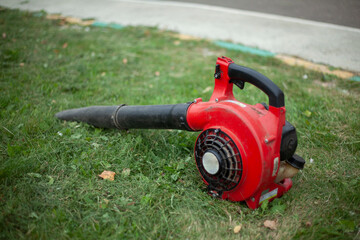 The garden vacuum cleaner lies on the grass.