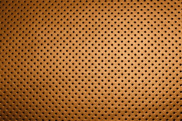 Modern luxury car brown leather interior. Part of perforated orange leather car seat details....