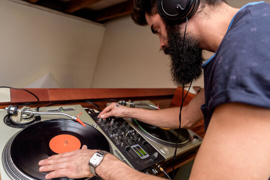 Bearded dj playing on mixing console