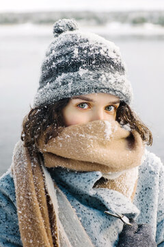 Woman in coat covering face with scarf