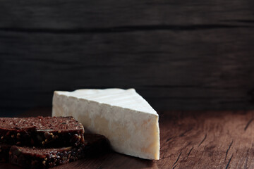 queso brie con pan nordique sobre la tabla 