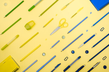 Stationery on yellow. Flat lay. Rows of tools, gradient colors from blue to green.