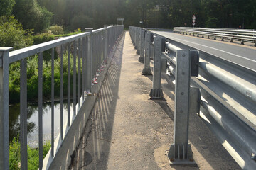 Obraz premium The fenced pedestrian area on the transport bridge ensures the safety of pedestrians.