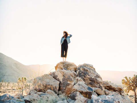 Woman atop boulders in desert