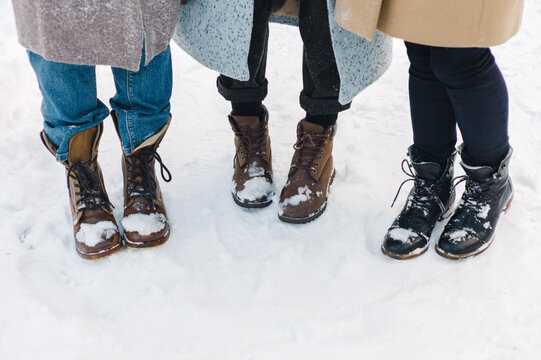 Crop female legs in boots on snow