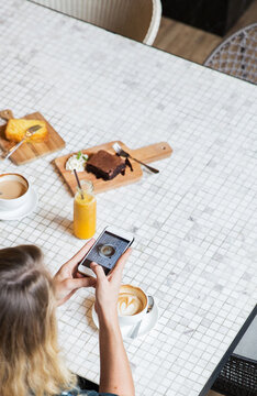 Woman taking a picture of her coffee for social media